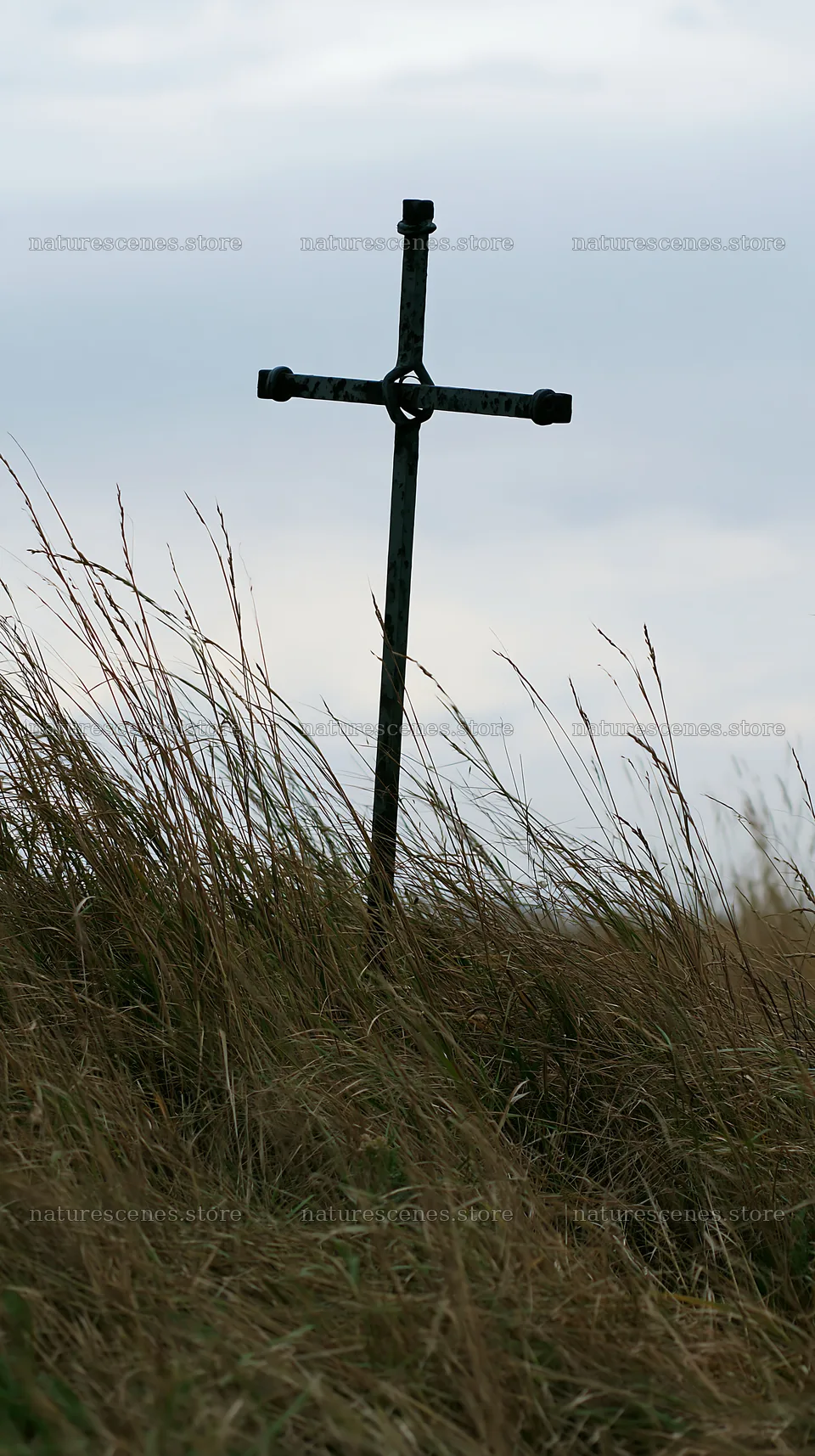Iron Christian cross in meadow overlooking valley landscape – nature scenes 5938x10608