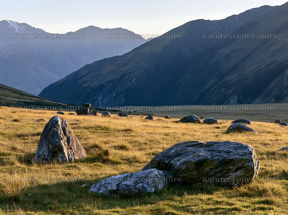 Meadow with boulders under mountains during daylight – nature scenes 9174x6866